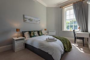a bedroom with a bed with a desk and a window at Luxury flat next to town centre Long-stay discount in Reading