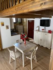 a dining room with a table and chairs and a tv at Casa Muscettola in Leporano