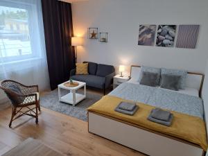 a bedroom with a king sized bed and a couch at Adam apartmán in Košice