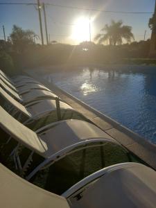 a row of chairs next to a swimming pool at Apart hotel la soñada in Federación