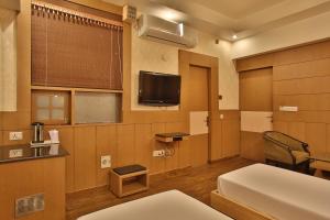 a hotel room with a bed and a tv at Hotel The Grand Chandiram in Kota