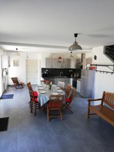 a dining room and kitchen with a table and chairs at GITE LA BLANCHE LONGERE in Compertrix