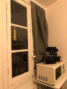 a microwave next to a window with the eiffel tower at Studio Passy - Tour Eiffel in Paris