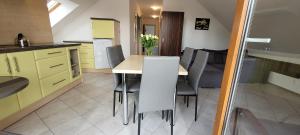 a kitchen with yellow cabinets and a table and chairs at Kama Pobierowo 2 in Pobierowo