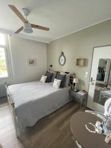 a bedroom with a bed and a table and a clock at Villa Les Terrasses à Tamaris vue mer exceptionnelle de chaque chambre, plage en bas du domaine in La Seyne-sur-Mer