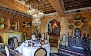 a dining room with a table and a fireplace at DAR ELHADIR in Tozeur