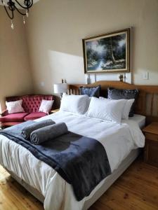 a bedroom with a large bed with a blue blanket on it at Uitenhage Apartment - 4 Graaff-Reinet Rd in Uitenhage