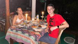 een man en vrouw aan een tafel met eten bij Sigiri Tarushan Home Stay in Sigiriya