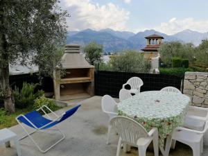 a table and chairs on a patio with a view of mountains at Residence Casa Maria in Assenza di Brenzone