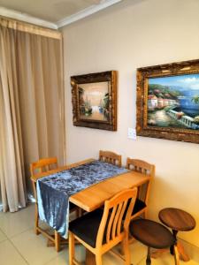 uma sala de jantar com uma mesa de madeira e cadeiras em Uitenhage Apartment - 4 Graaff-Reinet Rd em Uitenhage