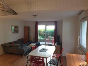ein Wohnzimmer mit einem Tisch und einem Sofa in der Unterkunft 62 m2 Rez de jardin, terrasse , 6 lits et parking in Annecy