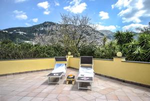 two chairs on a patio with mountains in the background at La Gaggia Guest House in Piano di Sorrento
