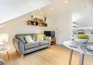 a living room with a couch and a table at Hendys Loft in St Ives