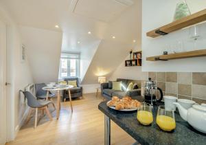 a kitchen and living room with a couch and a table at Hendys Loft in St Ives