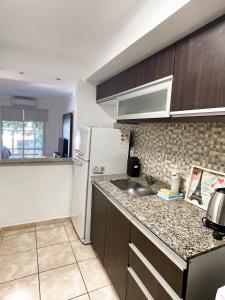 a small kitchen with a sink and a refrigerator at Regia Apartamentos Posadas in Posadas