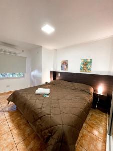 um quarto com uma cama grande num quarto em Regia Apartamentos Posadas em Posadas