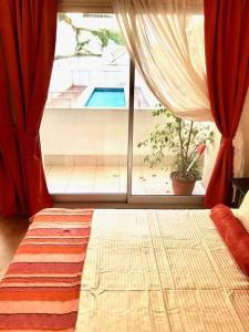 1 dormitorio con 1 cama con ventana y piscina en HART - STUDIO MELO en Buenos Aires