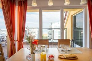 uma sala de jantar com uma mesa e uma grande janela em Strandpark-Grossenbrode-Haus-Windrose-Wohnung-14 em Grossenbrode