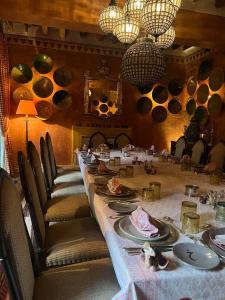 DAR ELHADIR في توزر: طاولة طويلة في غرفة مع كراسي وأطباق