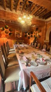 ein Esszimmer mit einem langen Tisch mit Tellern in der Unterkunft DAR ELHADIR in Tozeur
