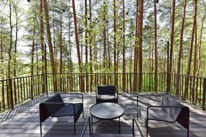 a deck with chairs and a table and some trees at Premium Forest Bungalow with Ofuro Tub in Luokesos Sen