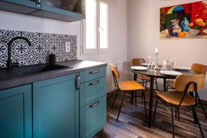 uma cozinha com um lavatório e uma mesa com cadeiras em Maison Ventoux em Carpentras