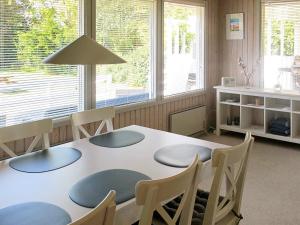 ein Esszimmer mit einem Tisch, Stühlen und Fenstern in der Unterkunft 4 person holiday home in Dannemare in Dannemare