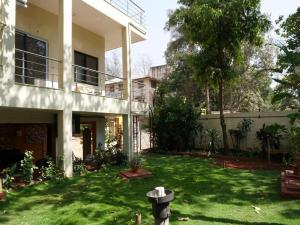 una casa con un patio con césped verde en Hotel Trisha Residency, en Lonavala