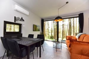 a dining room with a black table and chairs at Premium Forest Bungalow with Ofuro Tub in Luokesos Sen