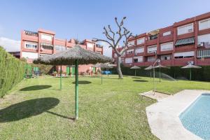 een groep parasols in het gras naast een zwembad bij Camarote de Algetares 2 in Algeciras