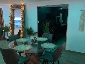 a dining room with a glass table and chairs at Escapade Zen Oasis Tropicale Spa Privatif in Loon-Plage