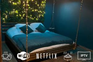 ein Schlafzimmer mit einem Schaukelbett mit einem Weihnachtsbaum in der Unterkunft Escapade Zen Oasis Tropicale Spa Privatif in Loon-Plage