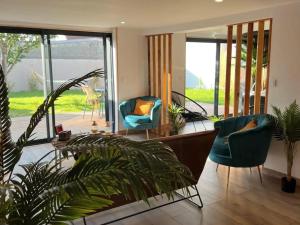 a living room with two chairs and a couch at Escapade Zen Oasis Tropicale Spa Privatif in Loon-Plage