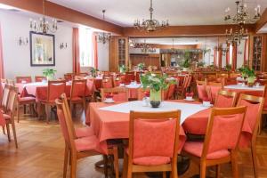 een eetkamer met tafels en stoelen met oranje stoelen bij Hotel-Restaurant Wiendl in Regensburg