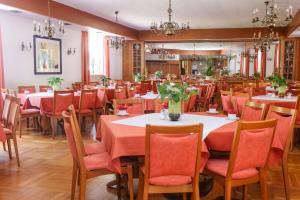 ein Esszimmer mit Tischen, Stühlen und orangefarbenen Stühlen in der Unterkunft Hotel-Restaurant Wiendl in Regensburg