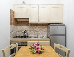 a kitchen with a table with a flower arrangement on it at B&B La Casa Nel Giardino in Piano di Sorrento