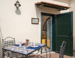 a table and chairs in a room with a green door at B&B La Casa Nel Giardino in Piano di Sorrento