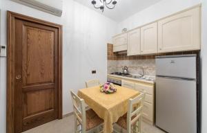a kitchen with a table and a white refrigerator at B&B La Casa Nel Giardino in Piano di Sorrento
