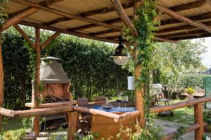 a wooden pergola with a table and an outdoor oven at B&B La Casa Nel Giardino in Piano di Sorrento