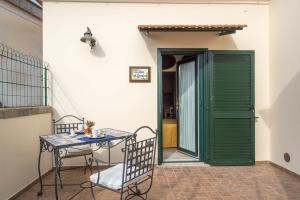 a table and chairs on a patio with a green door at B&B La Casa Nel Giardino in Piano di Sorrento