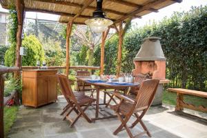 eine Terrasse mit einem Tisch, Stühlen und einem Herd in der Unterkunft B&B La Casa Nel Giardino in Piano di Sorrento