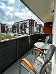 a balcony with a table and chairs and a view of a city at Alegria Avantgarden Brasov in Braşov