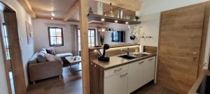 a kitchen with a sink and a living room at Hochalmbahnen Chalets Rauris 1-05 WE1 Maislaufeldweg 1h EG in Rauris