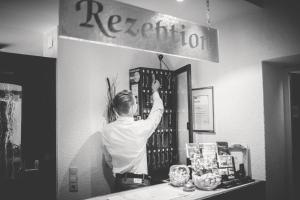 a man is standing at a counter in a store at Hotel-Restaurant Wiendl in Regensburg