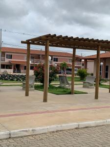 a wooden pergola in a park with benches at Aconchego in Petrolina