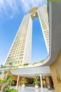 vistas a un edificio alto con palmeras en Intempo Sky Apartments 154 en Benidorm