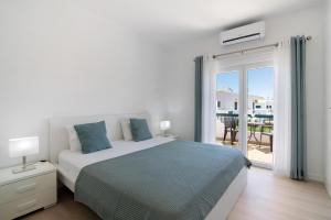 Un dormitorio blanco con una cama y un balcón. en Villa Janeca, en Albufeira 23 fotos más