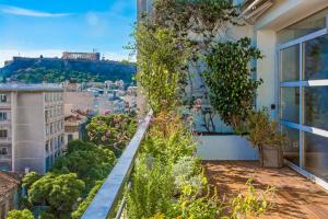 アテネにあるHidesign Athens Art Loft Penthouse Acropolis Viewの植物が植わるバルコニーから市街の景色を望めます。