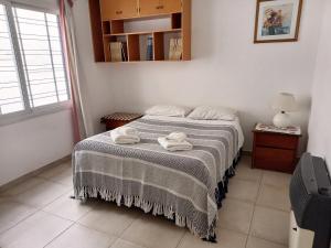 1 dormitorio con 1 cama con toallas en Apartamento de Aldi en Mendoza