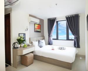 een slaapkamer met een groot bed en een raam bij Thành Nhân Hotel in Da Nang